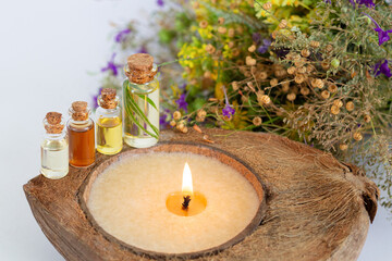 SPA set with herbal essential oils, burning candle and healthy wildflowers