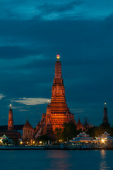 Naklejka premium Beautiful vertical view of famous Wat Arun, the Buddhist temple of dawn, in the light of the blue hour after sunset, Bangkok, Thailand