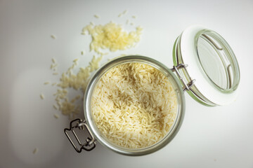 rice in glass container and some rice around, bulk concept, zero waste