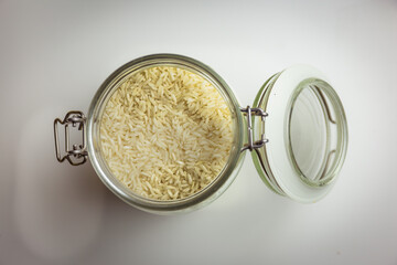 rice in glass container, white background, top down view