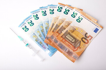 Seringue et billet de banque sur fond Blanc