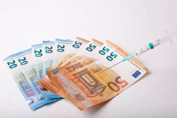 Seringue et billet de banque sur fond Blanc