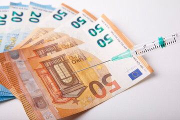 Seringue et billet de banque sur fond Blanc