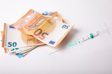 Seringue et billet de banque sur fond Blanc