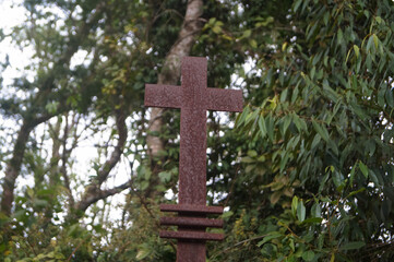 uma cruz enferujada com um fundo da floresta 