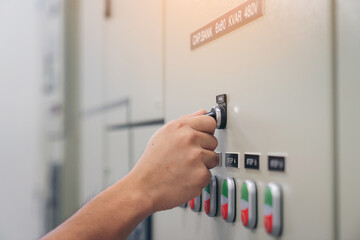 Electrical engineer man checking voltage and test at the Power Distribution Cabinet in the control...