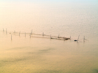 In fog disappears fantastic beautiful seascape overlooking fishing nets and horizon near coast of...