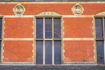 Architectural fragments of Historic building of Amsterdam central railway station. Building of Amsterdam central railway station first opened in 1889. Amsterdam, Netherlands.