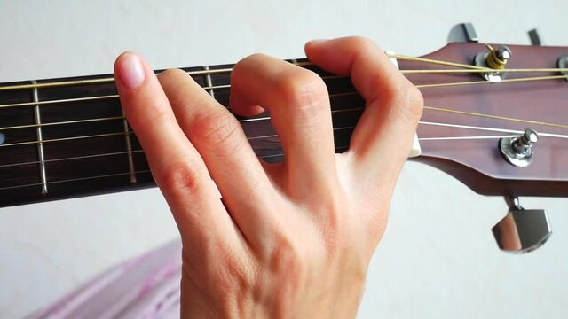A beautiful hand of a girl playing guitar close up