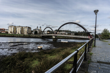 Una ría con un barco y un puente que la cruza.