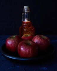 Apples and bottle of honey on a blue background