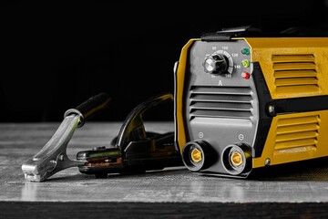 Inverter welding machine. Equipment for welding metals on a wooden desktop.