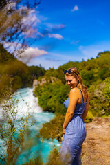 young woman in sunglasses in front of a waterfallw