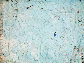Abstract ceramic mosaic on the building is painted with light paint. Venetian mosaic as decorative background. Selective focus. Pattern. Abstract mosaic colored ceramic stones