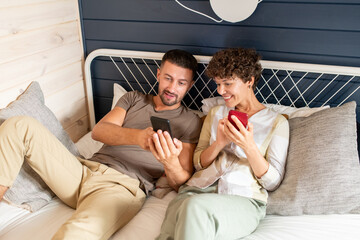 Obraz premium Young man showing his happy wife curious online video or post in social networks
