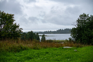 old wooden church on the island between trees in the rain