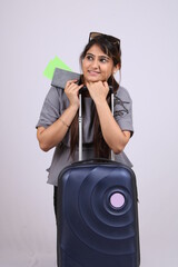 Beautiful smiling young Indian woman tourist holding passport and boarding pass isolated on white background.