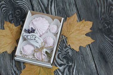 Zephyr in a box, a bouquet of lavender and dried maple leaves. On painted pine planks.