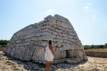 Chica mirando una construcción prehistórica. © Laura