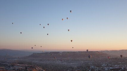 Hot Air Balloons rising in the sky during sunrise in Cappadocia in Göreme, Turkey.
