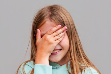 Woman covering her eyes isolated on a gray background