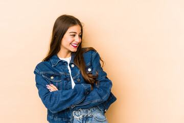 Young caucasian woman isolated en beige background smiling confident with crossed arms.