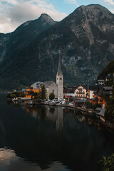 Fototapeta na wymiar Panorama view of the cute old town located at the Hallstätter Lake on a moody dark rainy day with clouds in the mountains. Hallstatt, Austrian Alps, Salzkammergut in Austria, Europe