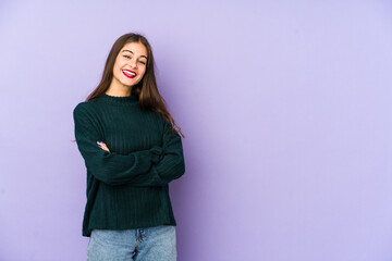 Young caucasian woman isolated on purple background who feels confident, crossing arms with determination.