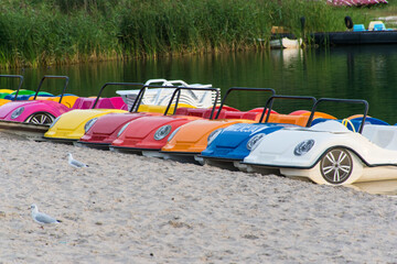 car-shaped pedal boats moored to the beach