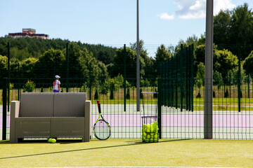 tennis court, tennis racket and tennis balls in the basket