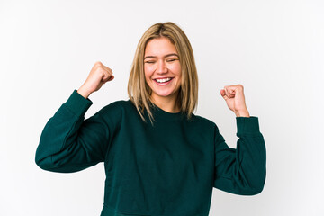 Young blonde caucasian woman isolated celebrating a victory, passion and enthusiasm, happy expression.