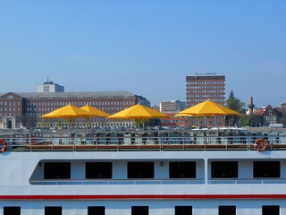 Fototapeta na wymiar Riverboat cruise deck with yellow sunshade umbrellas and seats at the Danube beach in Budapest