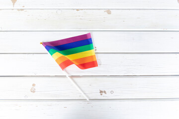 Pride flag on white wooden planks background.