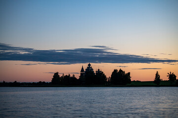 Naklejka premium vintage churches on the island at sunrise on the background of the lake