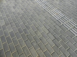 Grey concrete pavement on the sidewalk with a regular square pattern in a bus station in Budapest, Hungary