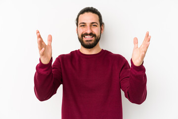 Naklejka premium Young long hair man isolated on a white background receiving a pleasant surprise, excited and raising hands.