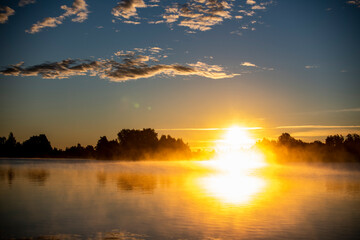 Obraz premium fog on the lake through green reeds at sunrise