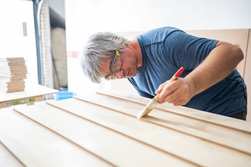 Carpenter applying varnish to the furniture he is building.