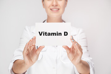 Vitamin Dwritten on a card in doctors hands