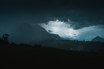 Heavy summer thunderstorm weather with moody dark vibes in the mountains with panorama landscape...