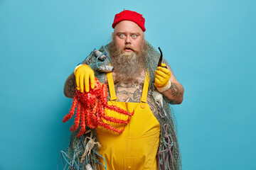 Shocked bearded seaman works on ship, smokes pipe with surprised expression, holds big caught...