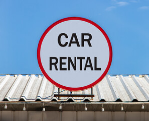 A Circle billboard with text Rental Car, is installed on a roof. Offer of hire car. Renting cars service.