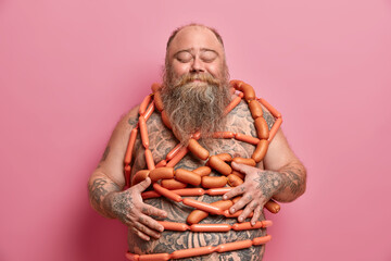Obese overweight man has unhealthy nutrition, bad habits, wrapped with sausages, has diet failure,...