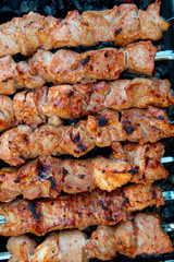 skewered pork kebab grilled over charcoal, smoke over a barbecue, medium cooking, close
