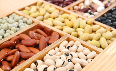 The ranks of different beans: kidney, roman, black eye,edamame, adzuki View from above in wooden box
