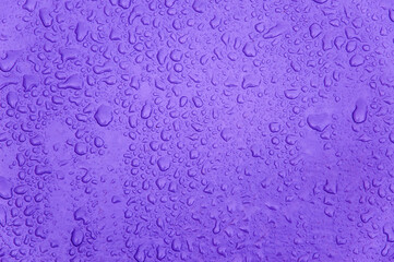 small and large drops of condensation on frosted colored glass