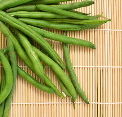 small and slender green beans (haricot vert) on a bamboo mat