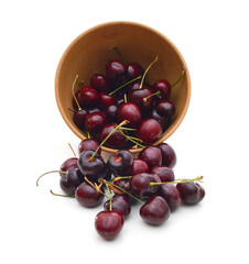 fresh cherries on wooden bowl over white