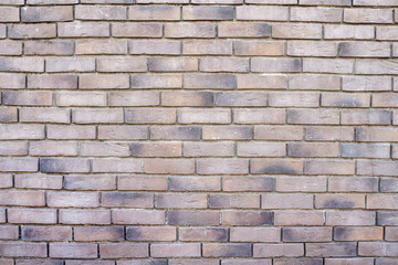 The wall is made of beige decorative bricks.