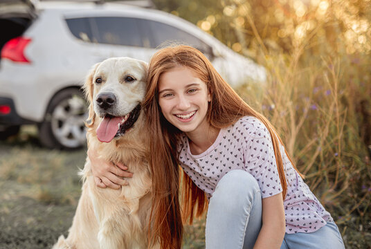 Portrait of teenage girl petting golden retriever - Powered by Adobe
